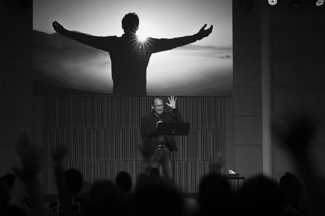 Speaker presenting confidently on stage to an audience