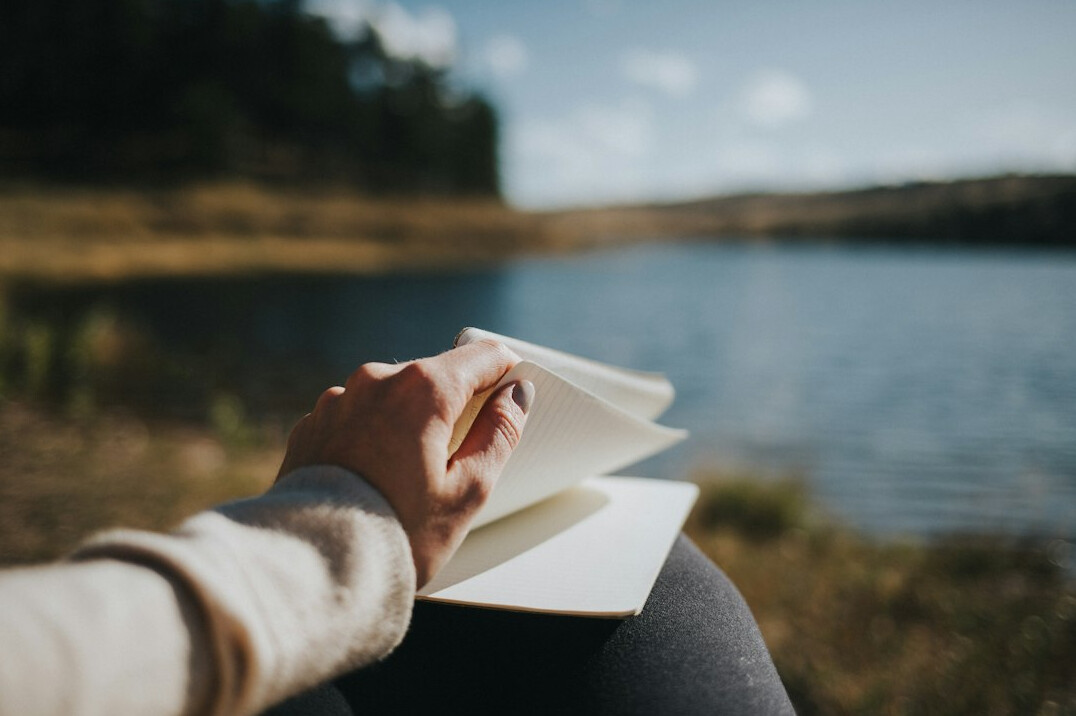 Person writing in a journal at a desk